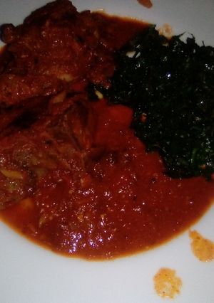 A picture of Chicken in gravy sauce and pan-fried kales.