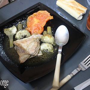 Secreto con alcachofas y tomate