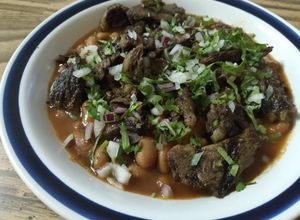 Una foto de Frijoles con arrachera, cilantro y cebolla morada