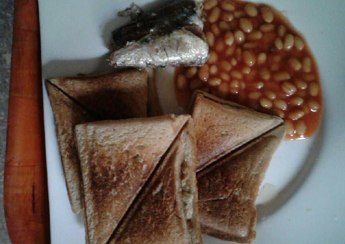 Scrambled eggs in a Toast with sardine and baked beans