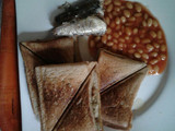 Scrambled eggs in a Toast with sardine and baked beans