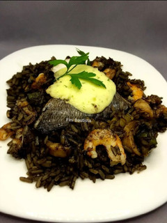 Una foto de Arroz negro con dorada al horno