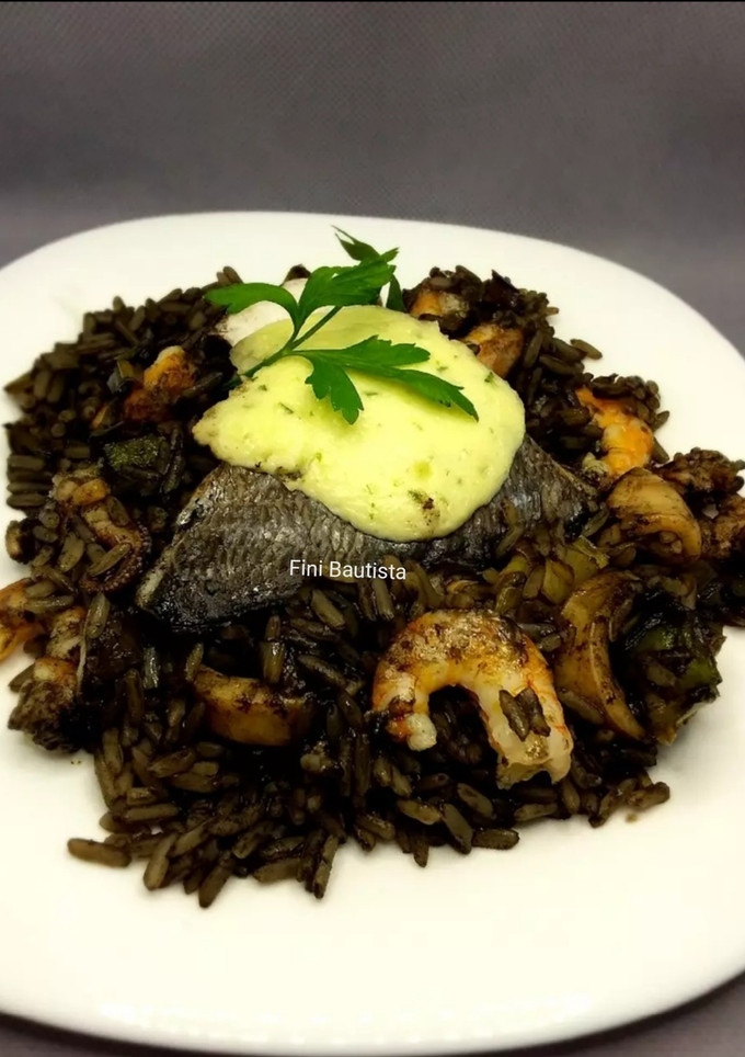 Una foto de Arroz negro con dorada al horno