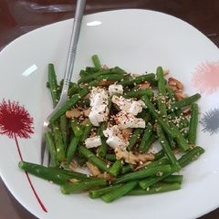 A picture of French beans tossed with nuts and feta cheese salad.