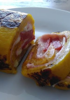 Una foto de Rollo de Plátano maduro relleno de jamón, queso y bocadillo