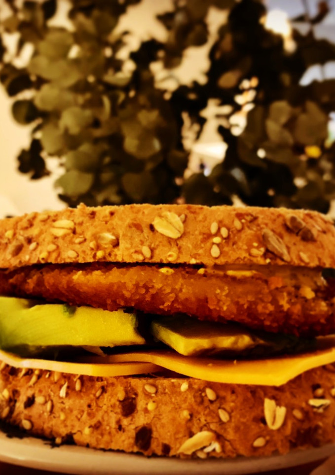 Una foto de Sándwich de pechuga de pollo empanada con salsa de curry y mango