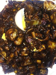 Una foto de Chipirones en su tinta con patatas y berberechos
