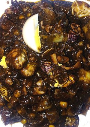 Una foto de Chipirones en su tinta con patatas y berberechos