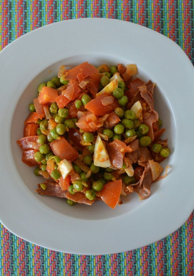 Una foto de Guisantes con jamón, tomate y huevo cocido