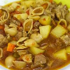 A picture of Guiso de carne de cerdo 🐷 con caracolitos en olla de hierro 🍲.