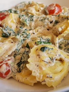 Una foto de Tortellinis en salsa con tomate y espinacas