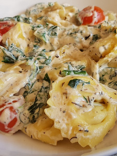 Una foto de Tortellinis en salsa con tomate y espinacas