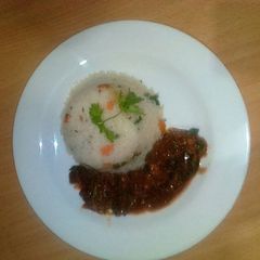 A picture of Beef stew served with vegetable rice.