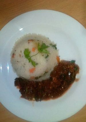 A picture of Beef stew served with vegetable rice.