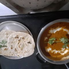 A picture of Paneer butter masala with garlic nan.