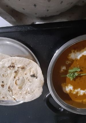 A picture of Paneer butter masala with garlic nan.