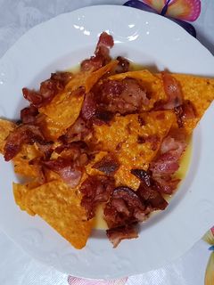Una foto de Nachos con cheddar y bacon