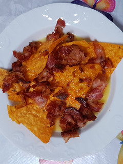 Una foto de Nachos con cheddar y bacon