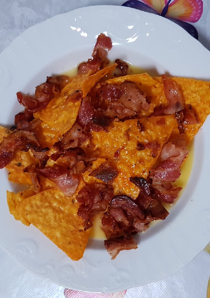 Una foto de Nachos con cheddar y bacon
