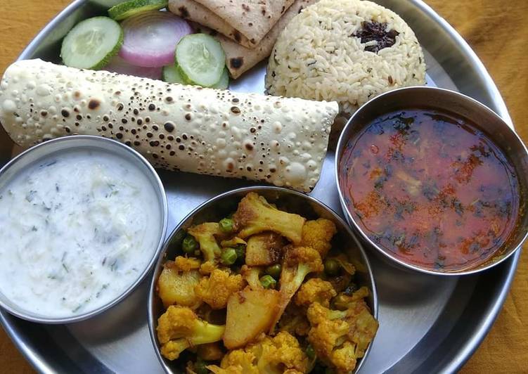 Lunch platter sabji dal raita rice papad roti salad