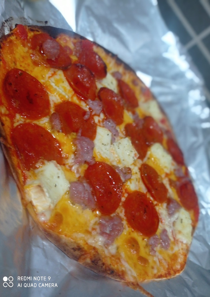 Una foto de Pizza de quesos y pepperoni con base de pan pita  o tortilla de trigo