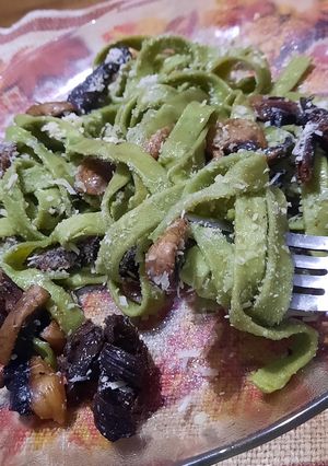 Una foto de Fideos verdes con champiñones y hongos de pino