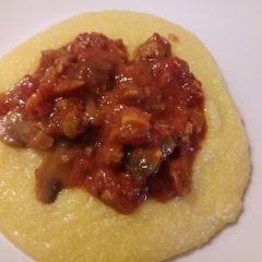 A picture of Polenta with sausage and porcini mushrooms.