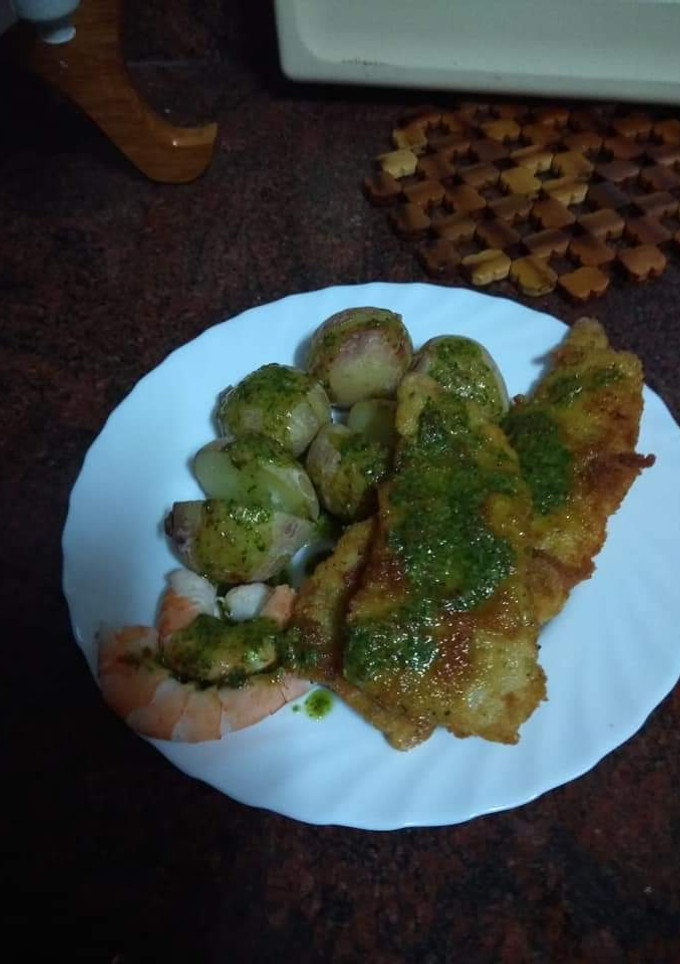 Una foto de Merluza empanada con papas arrugás, langostinos y mojo verde
