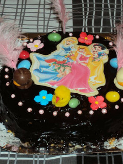 Una foto de Mona de chocolate negro rellena de mermelada de fresa y con princesas