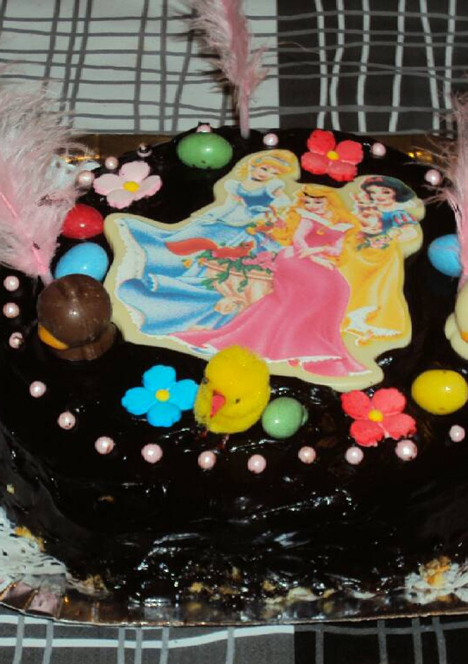 Una foto de Mona de chocolate negro rellena de mermelada de fresa y con princesas