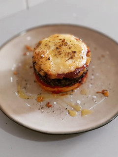 Una foto de Timbal de patata, piquillo, morcilla y manzana gratinado