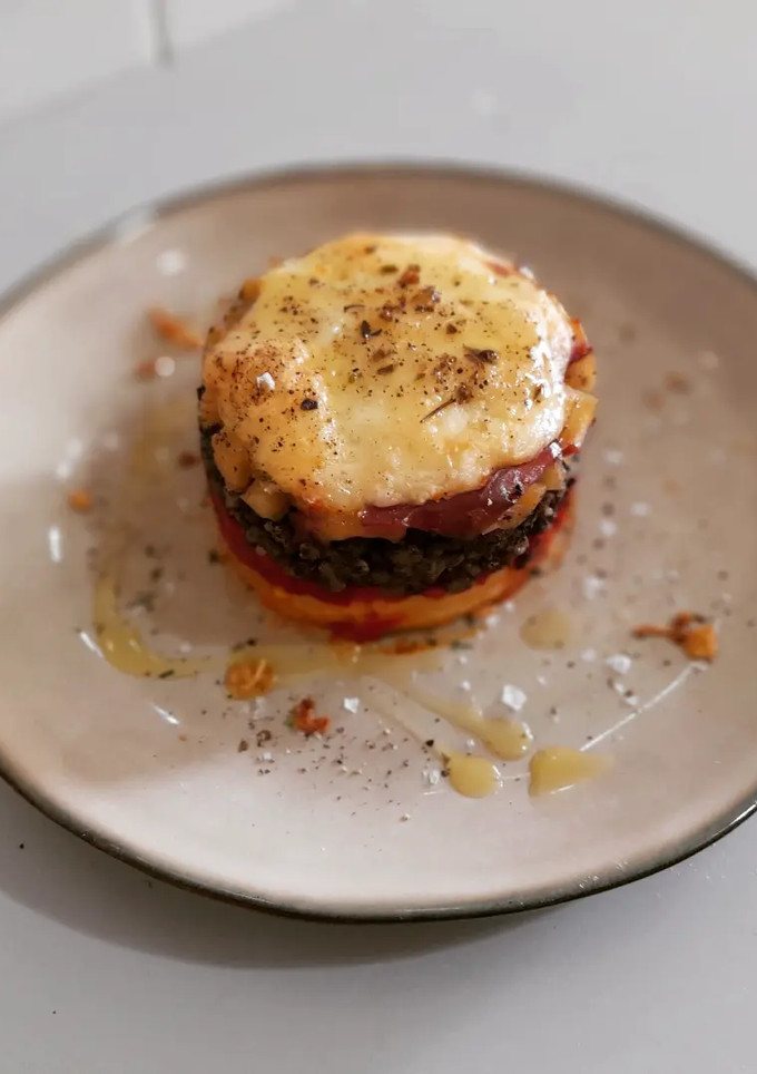 Una foto de Timbal de patata, piquillo, morcilla y manzana gratinado