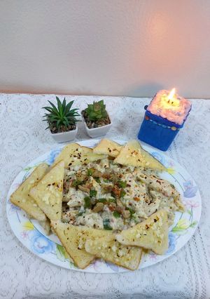 A picture of Chicken cheese pasta with garlic bread.