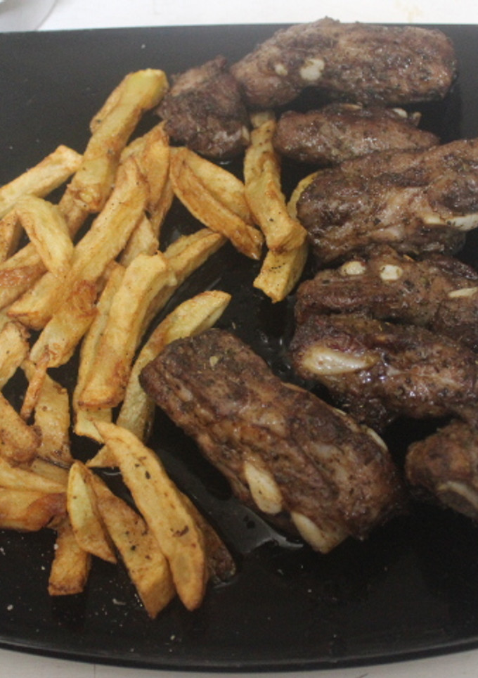 Una foto de Costillar adobado con patatas fritas