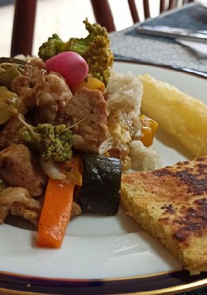 Una foto de Wok de Cerdo con vegetales, arroz, tajada de yuca y arepa