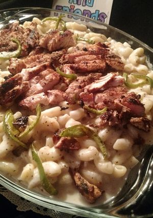 A picture of White sauce pasta with grilled chicken.