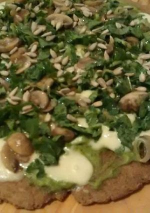 Una foto de Pizza de rúcula y champiñones con salsa de palta