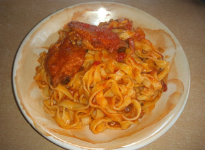 Una foto de Fideos caseros con tuco y alitas de pollo