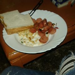 A picture of Fried egg with fried sausages.