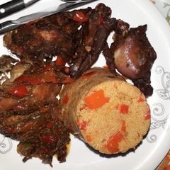 A picture of Jollof couscous with peppered chicken.