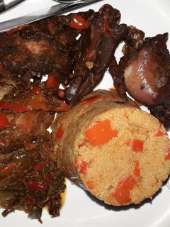 A picture of Jollof couscous with peppered chicken.