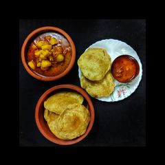 A picture of Puri and Aloo tomato curry.