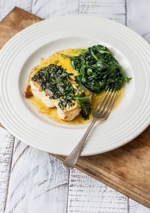 A picture of Pan Roasted Hake with black butter sauce and seasonal veg.