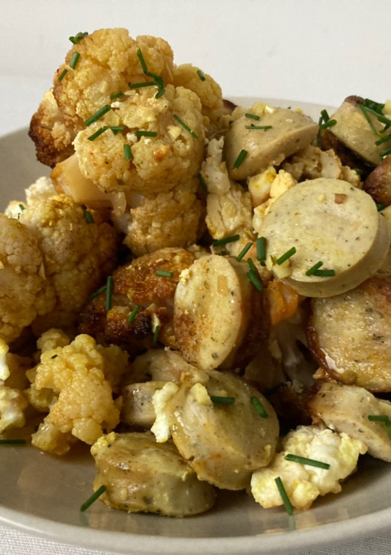 Una foto de Coliflor al horno al curry con salchichas alemanas