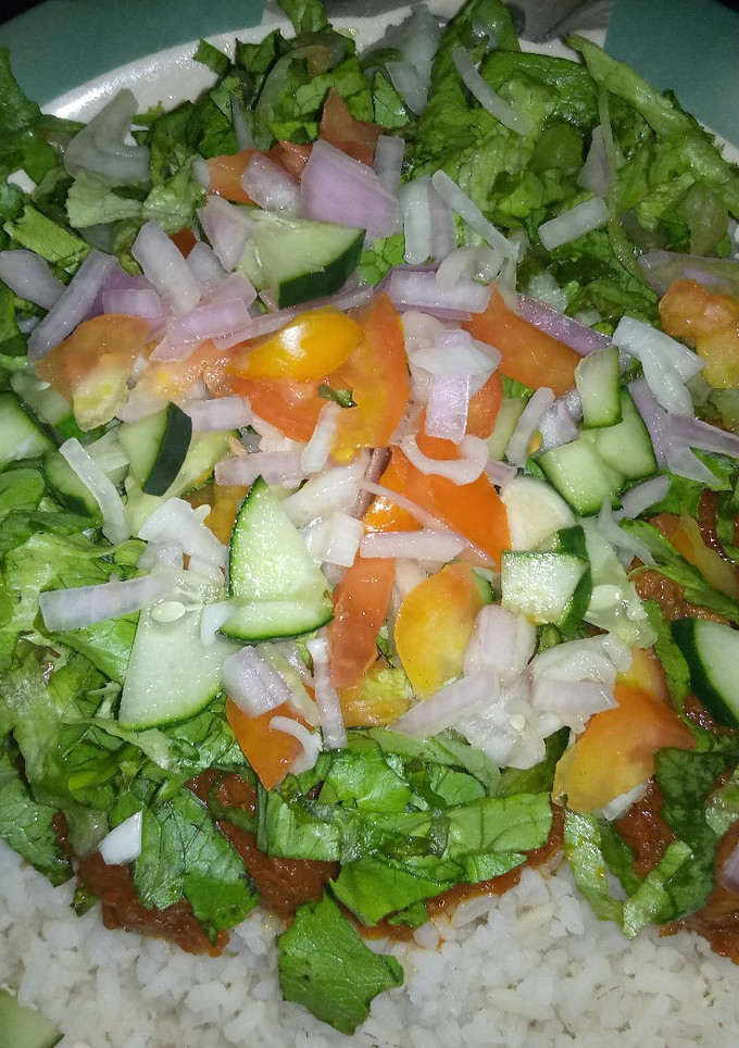 A picture of Rice and stew with salad.