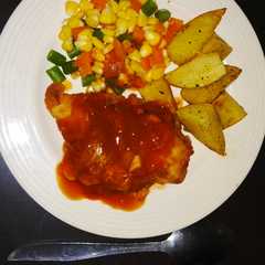 A picture of Chicken steak crispy with bbq sauce & potato wedges.