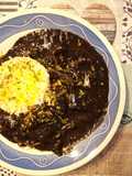 Calamares de potera en salsa de verduras y tinta con arroz blanco y escamas de naranja
