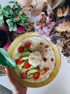 Una foto de Tortilla de trigo con aguacate, tomates cherry y huevo poché