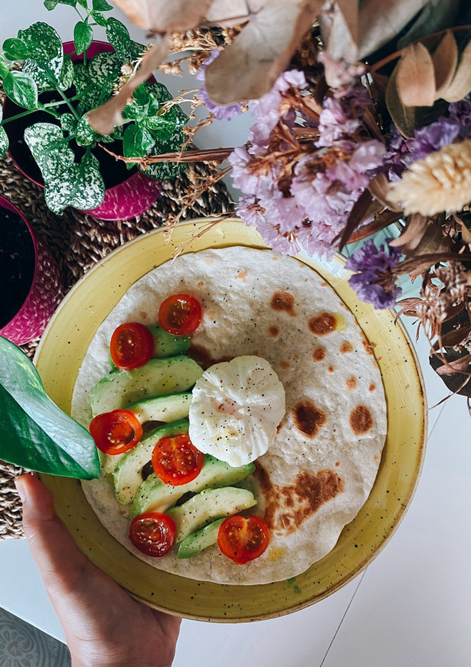 Una foto de Tortilla de trigo con aguacate, tomates cherry y huevo poché