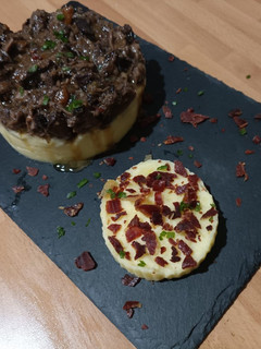Una foto de Timbal de rabo de toro y puré de patatas con crujiente de jamón